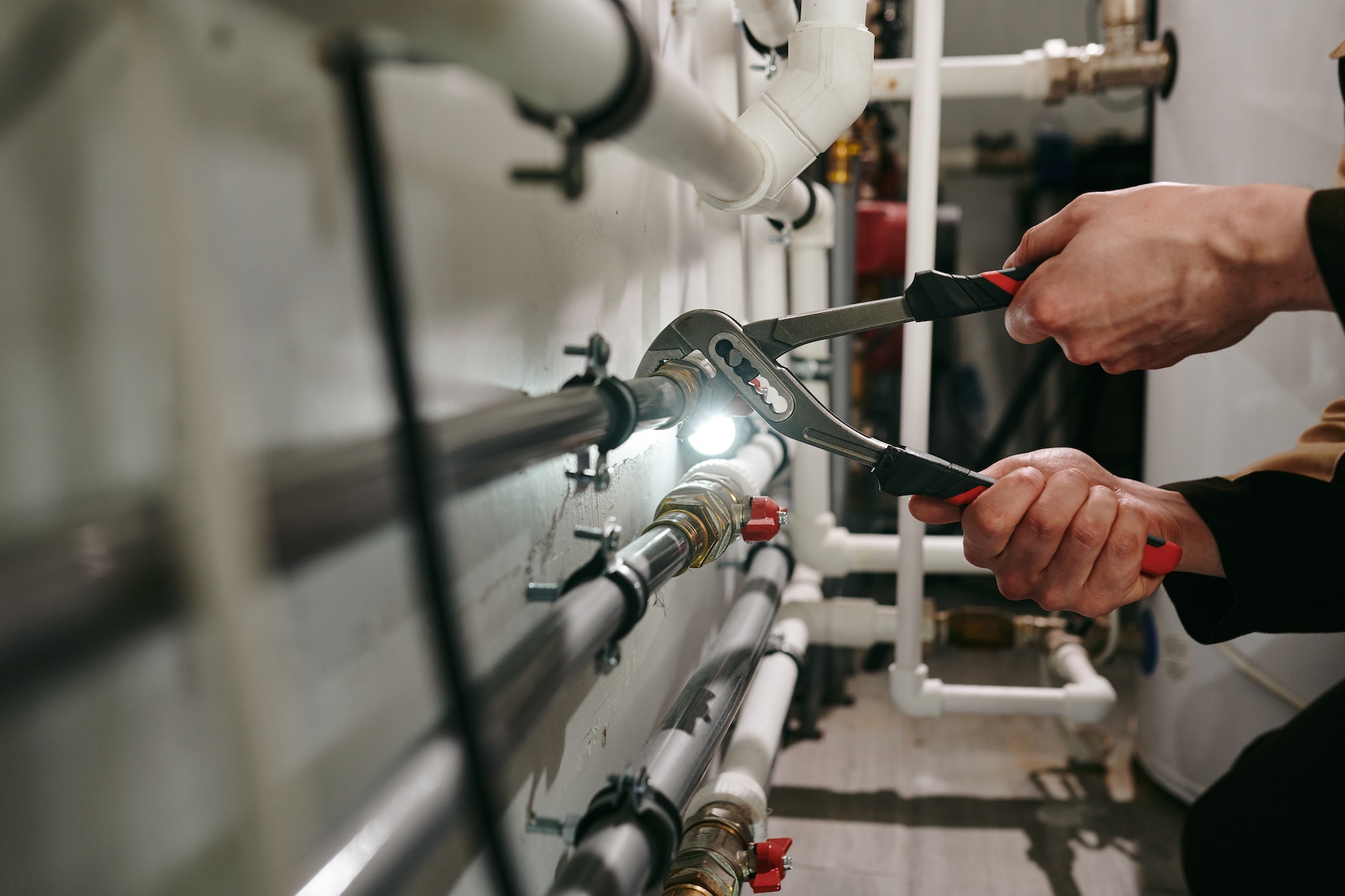 Hands of technician or plumber repairing broken pipes